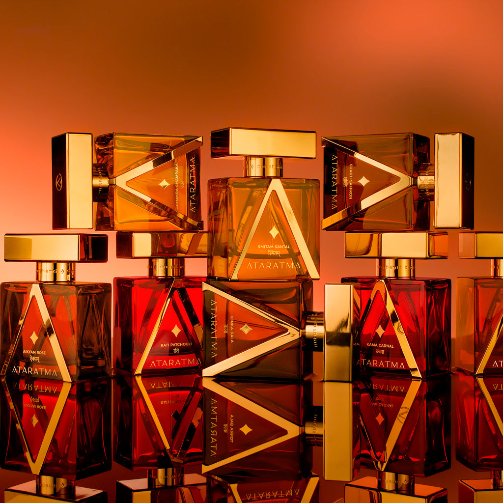 Collection of Ataratra perfume bottles with a warm, reflective background